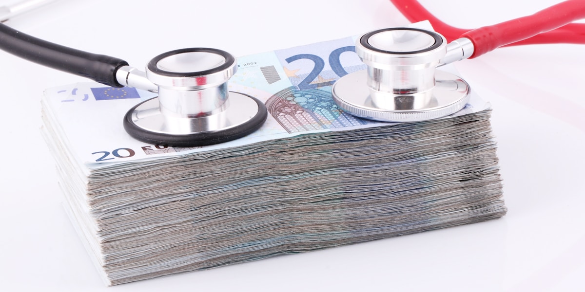 Money and stethoscope representing expensive healthcare costs
